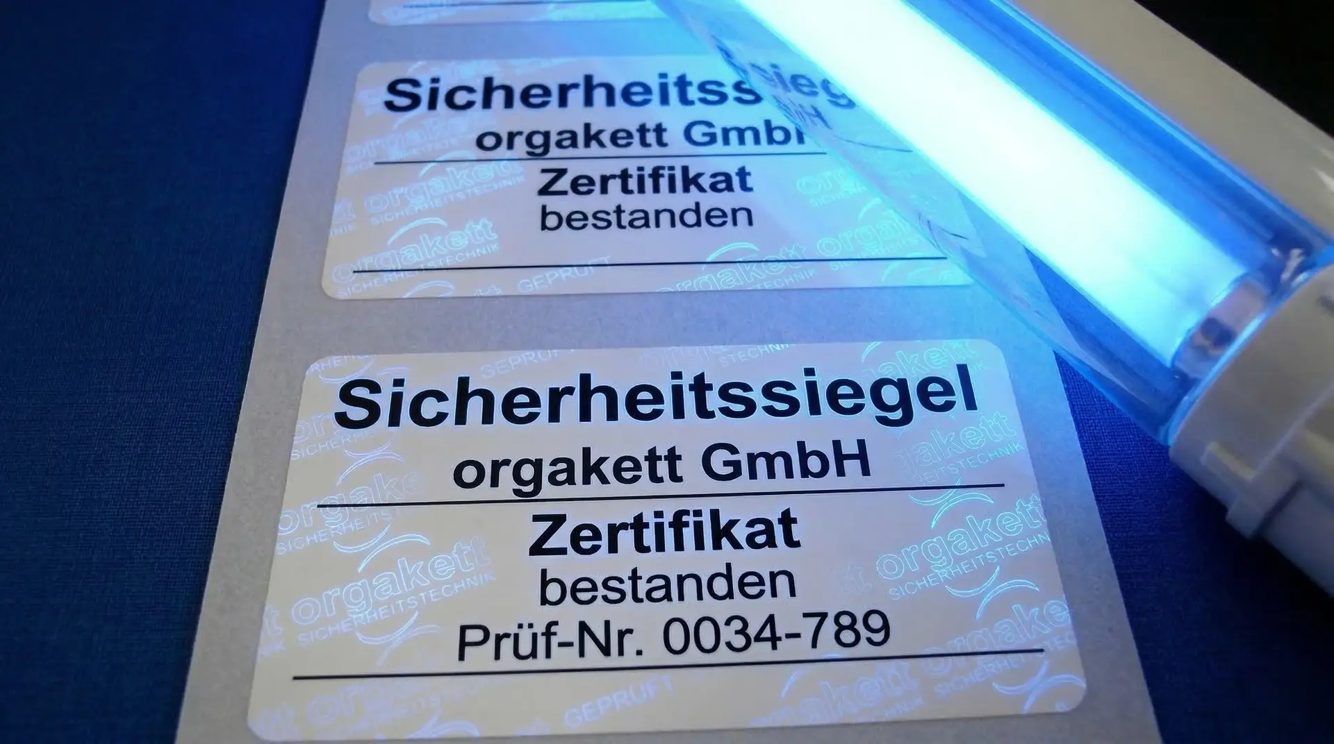 Lumineszenz-Sicherheitsetiketten mit Zertifikat-Aufdruck und Prüf-Nr. unter UV-Licht