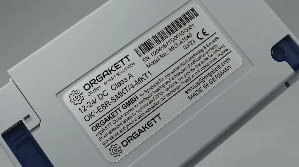 Silbernes PET-Typenschild mit Barcode und Orgakett Smart Solutions auf Kunststoffgehäuse