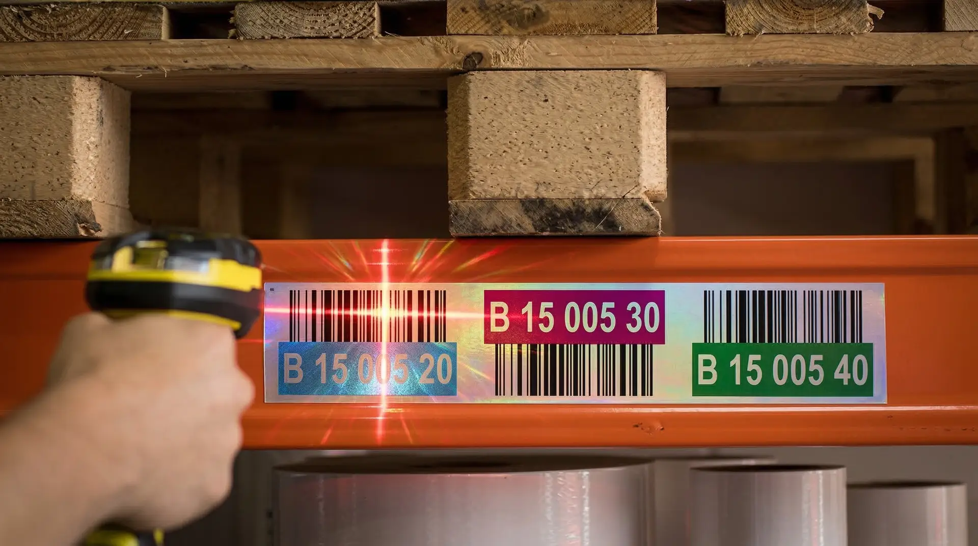 Barcode-Scanner scannt reflektierendes Regaletikett B 15 005 30 an orangenem Hochregallager